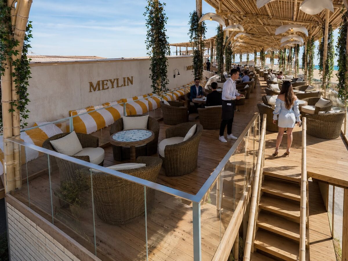 Terraza Meylin de AQUALODGE con sofás y sombrillas frente a la playa, Tumbes